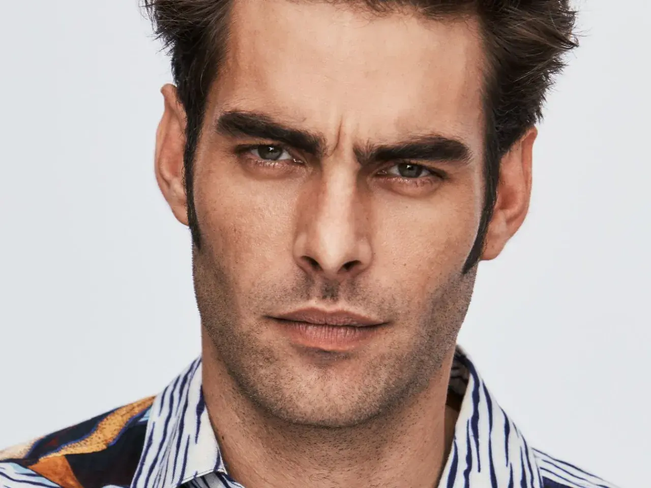 Primer plano de Jon Kortajarena con mirada intensa y camisa estampada.