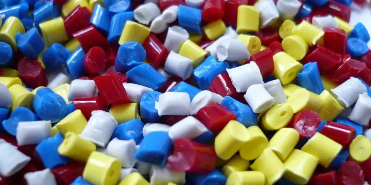 Gran cantidad de gránulos de poliamida de colores vibrantes: rojo, azul y amarillo.