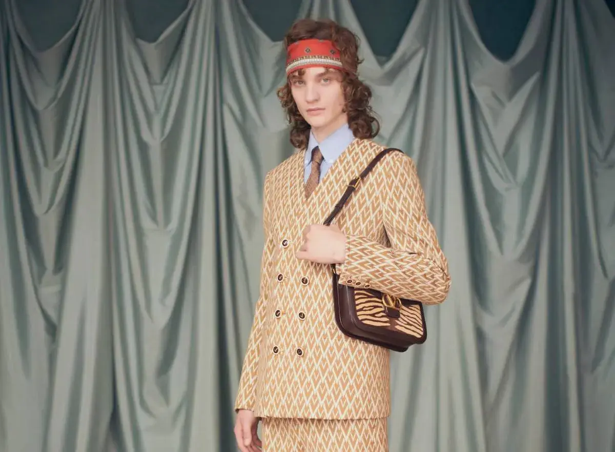 Modelo con traje estampado y bolso de cebra, un look que evoca la audacia de Alessandro Michele.