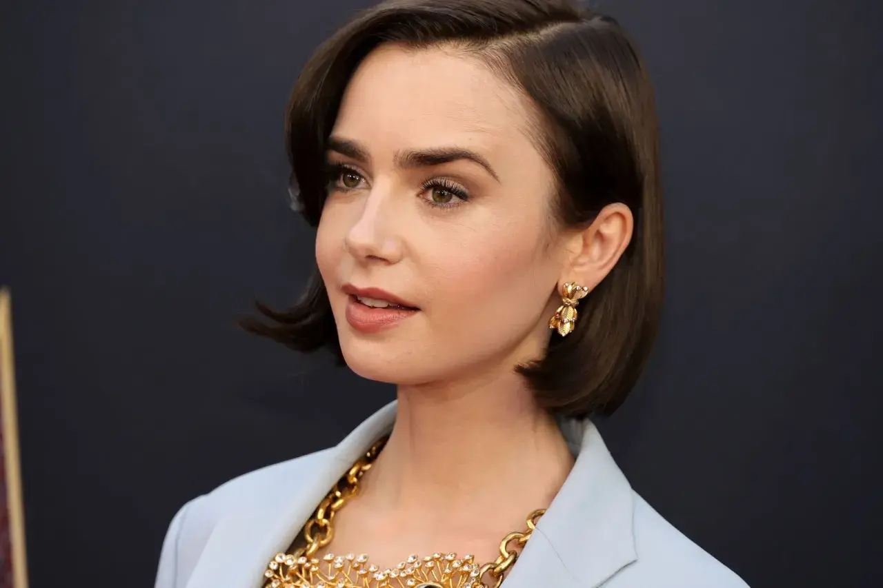 Mujer con un corte de pelo estilo **italian bob**, pendientes dorados y un collar llamativo.