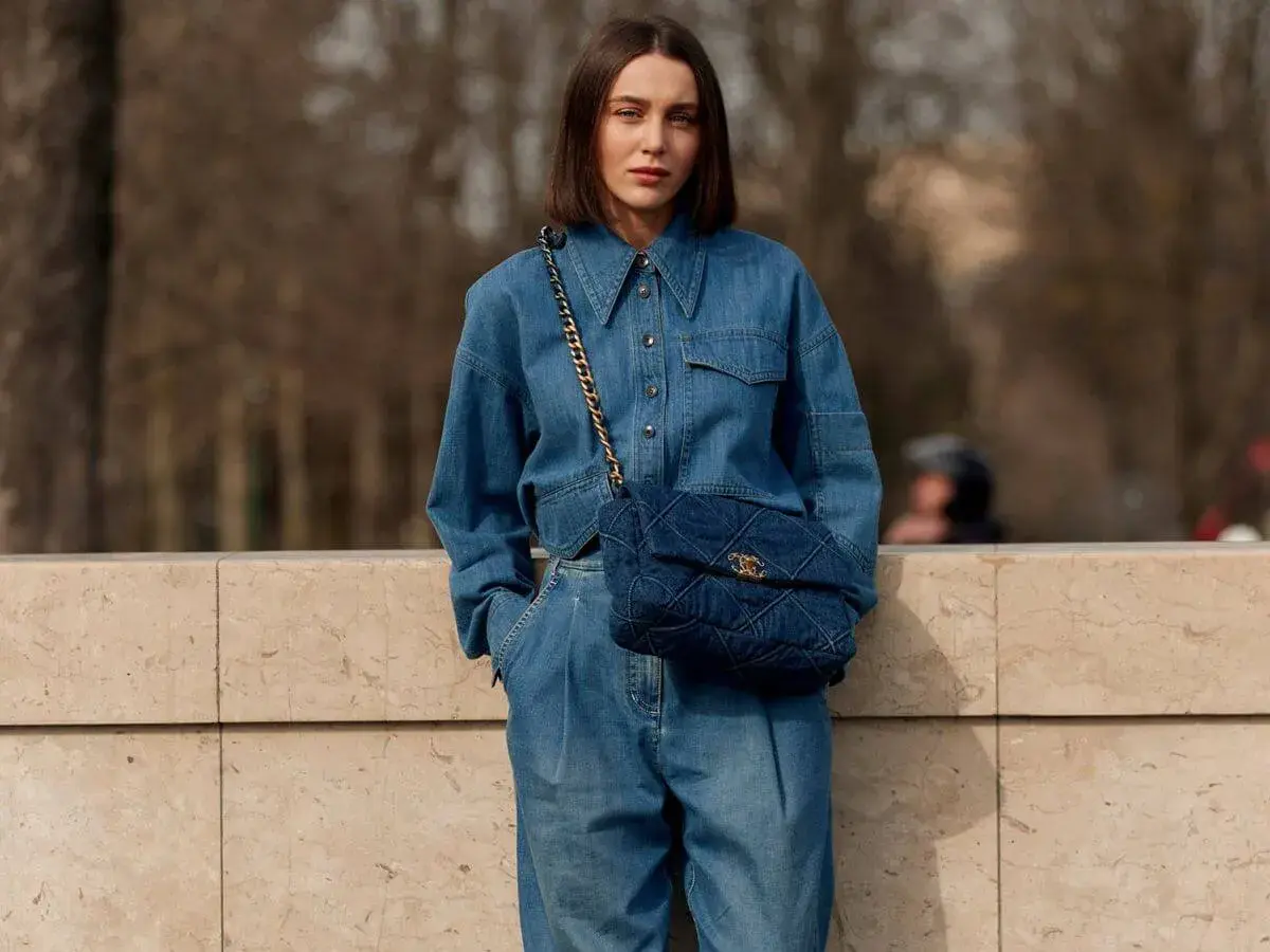 Mujer con un look total denim, combinando mono vaquero con bolso acolchado.