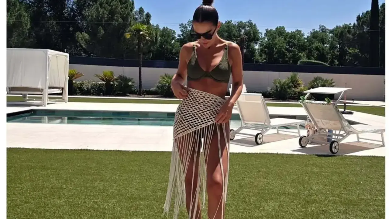 Paula Echevarría luce un bikini verde y una falda de crochet con flecos junto a la piscina, disfrutando del sol.