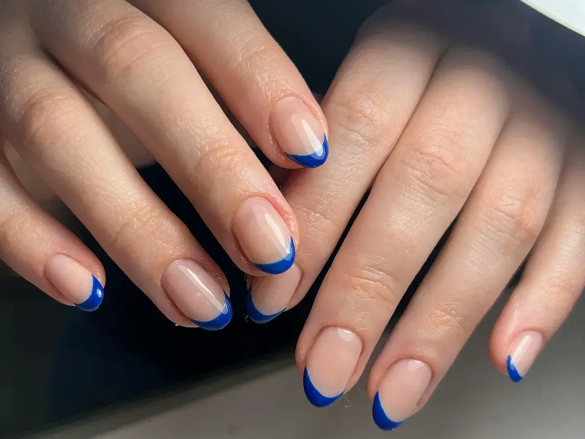 Manos con uñas francesas originales en azul vibrante. Un toque moderno y chic para un look sofisticado.