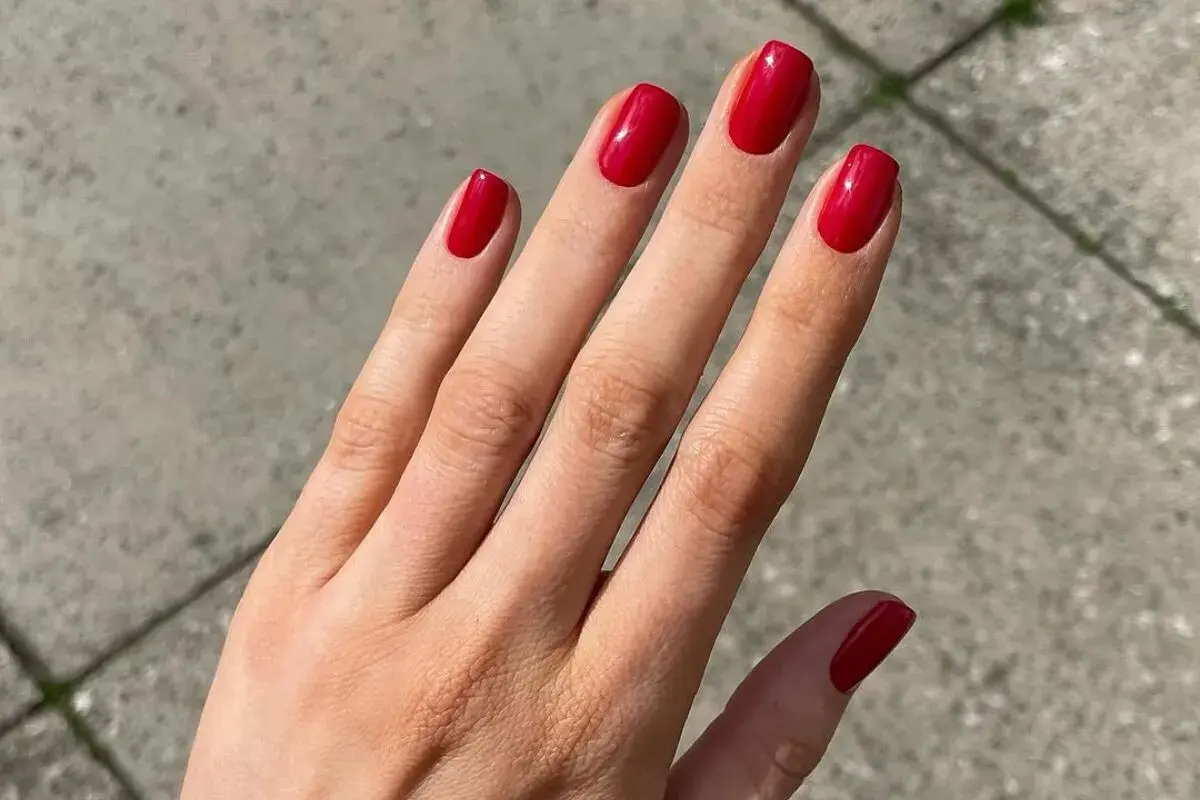 Manos con uñas rojas decoradas elegantes, un toque de glamour para cualquier ocasión.