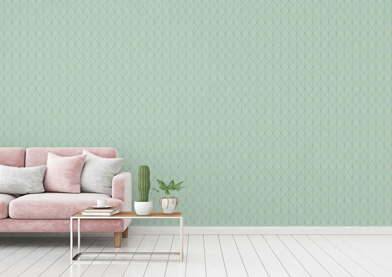 Sofá rosa y cojines blancos sobre suelo de madera. La pared de fondo tiene un patrón de rombos en colores que combinan con el verde agua.