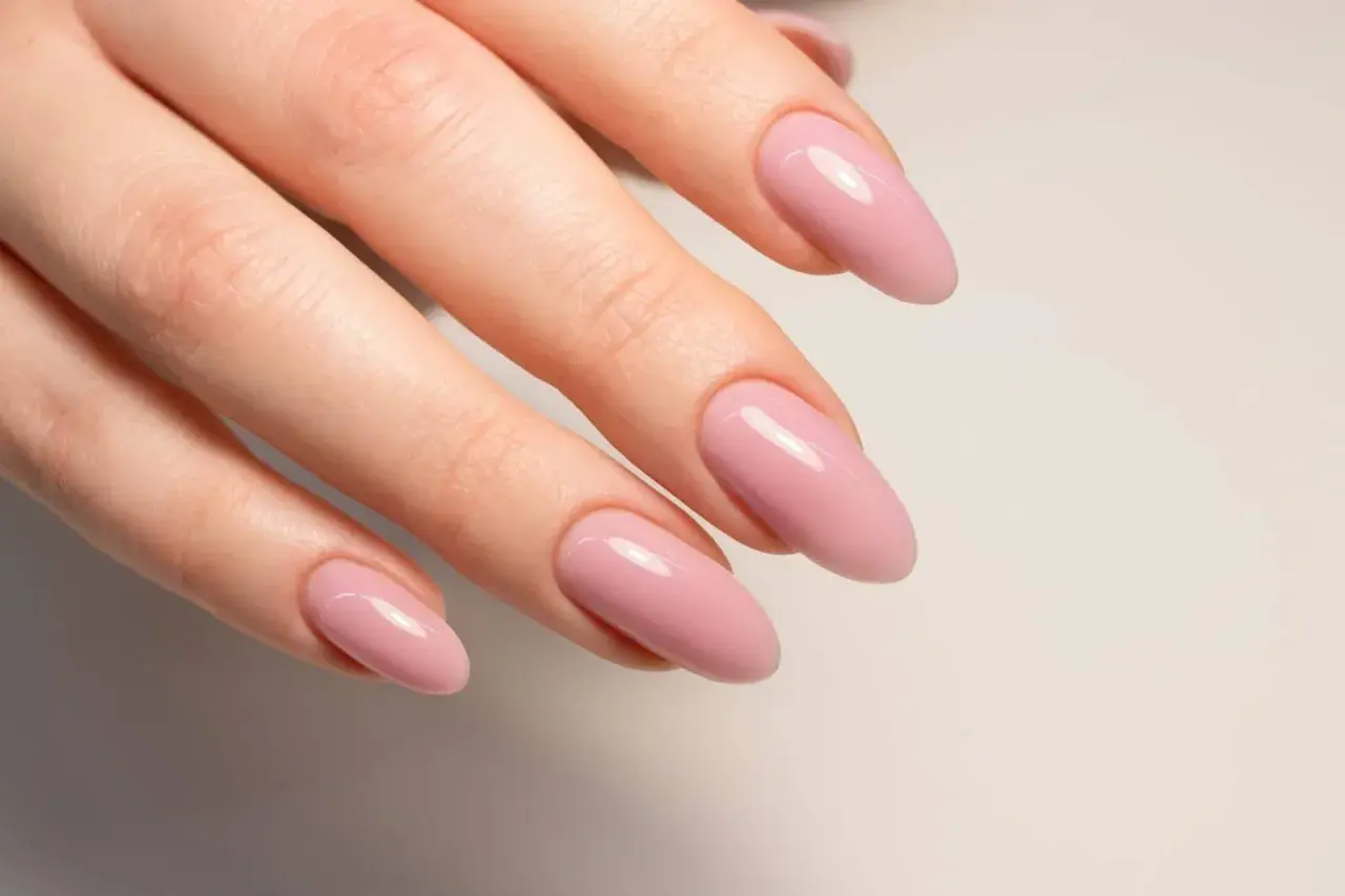 Manicura con uñas semipermanentes naturales en tono rosa pálido, con forma almendrada y acabado brillante.