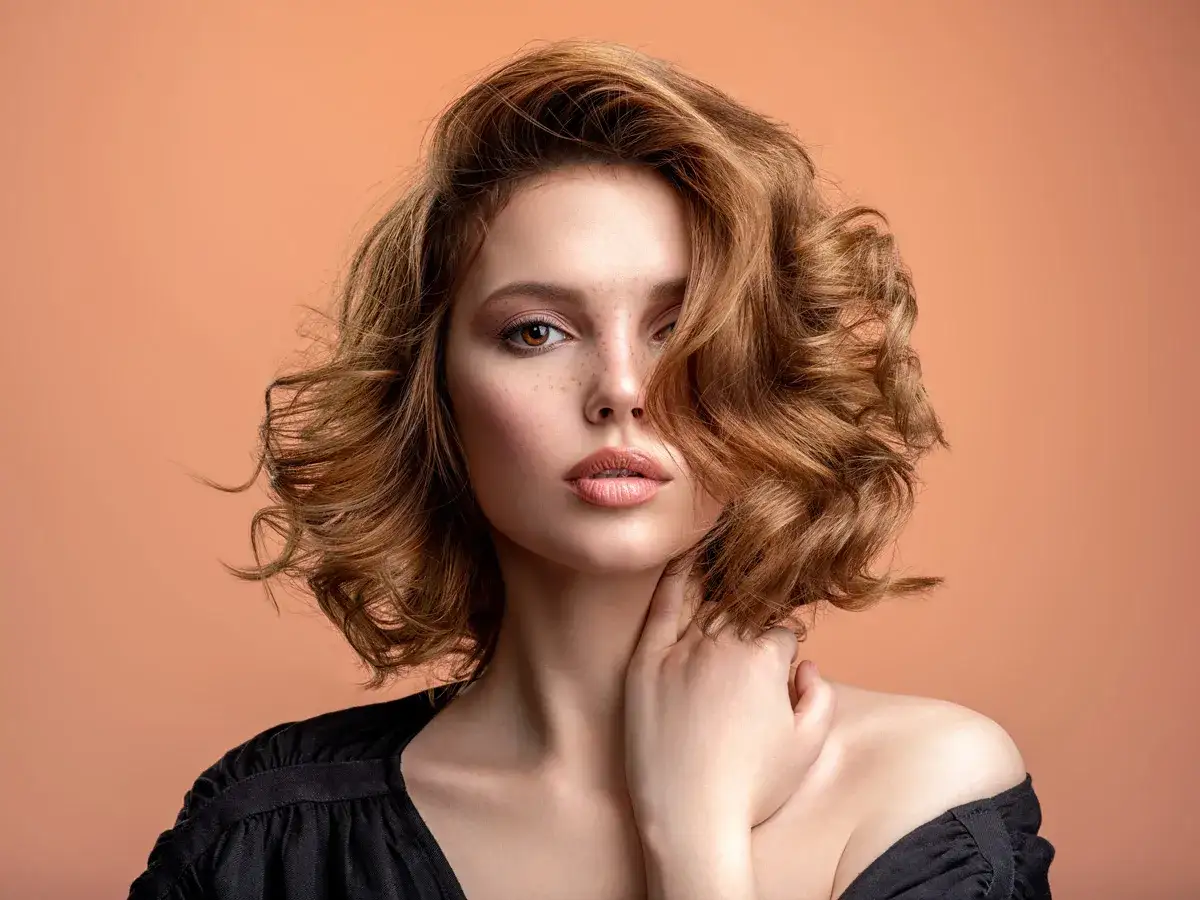 Mujer con cabello rizado y castaño, ideal para cortes de pelo para dar volumen al pelo fino.