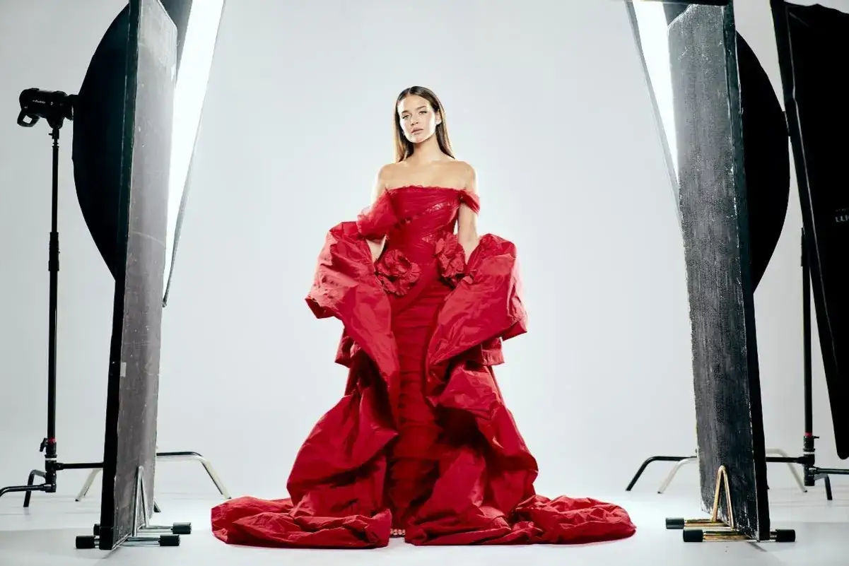 Laura Escanes, deslumbrante con un vestido rojo voluminoso, posa entre luces de estudio.