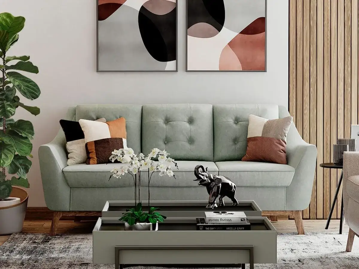 Sofá verde menta con cojines de verde oliva color combinaciones. Mesa de centro con elefante y orquídeas.
