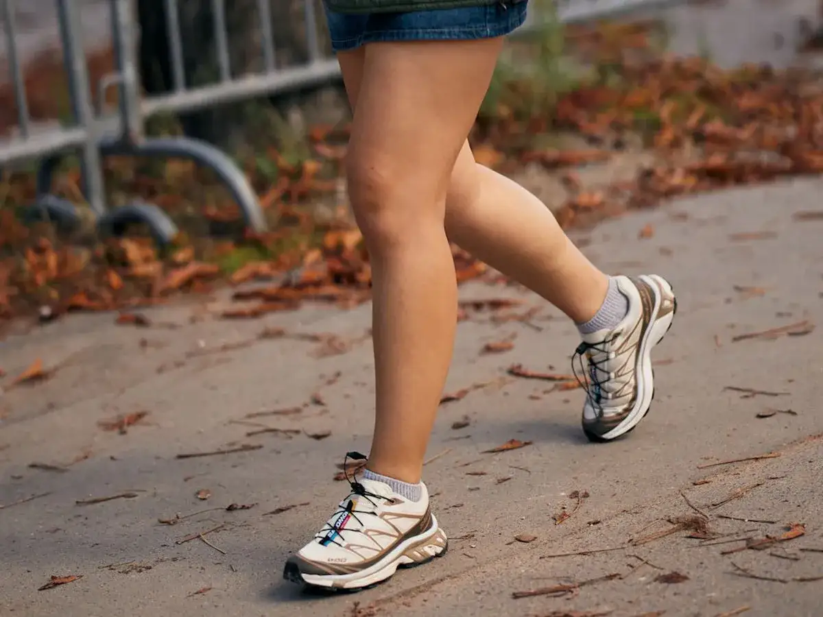 Piernas caminando con zapatillas tendencia, ideales para un look urbano y cómodo.