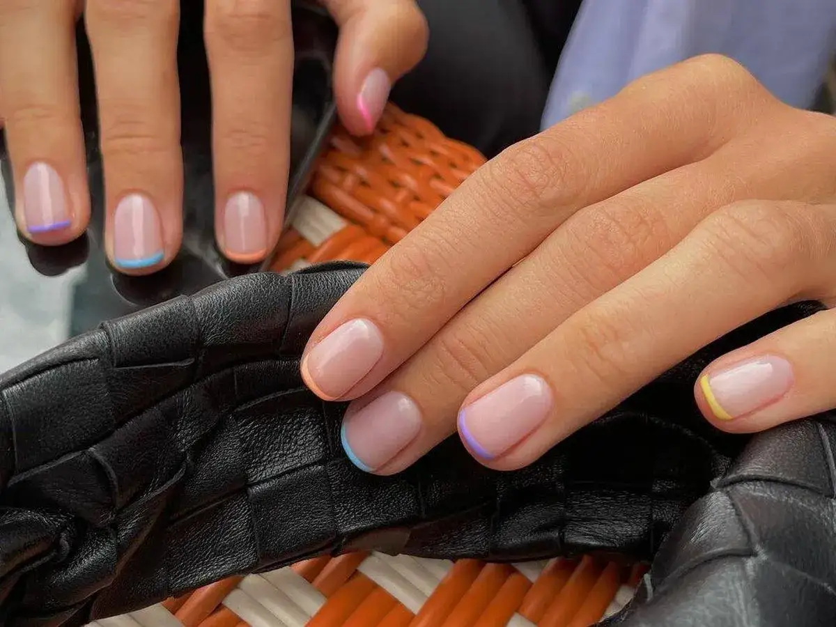 Manicura francesa con puntas de colores vibrantes: azul, morado, naranja, rosa y amarillo.