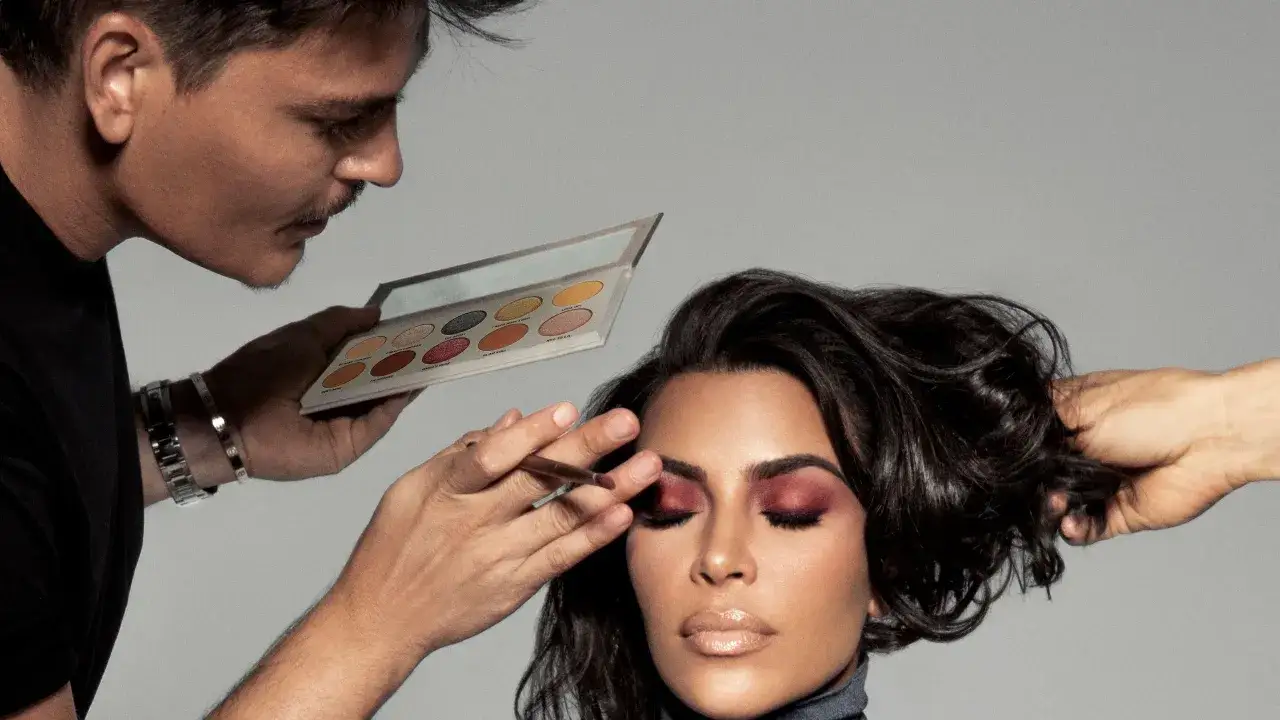 Mario Dedivanovic aplica sombra de ojos a Kim Kardashian, quien tiene los ojos cerrados.