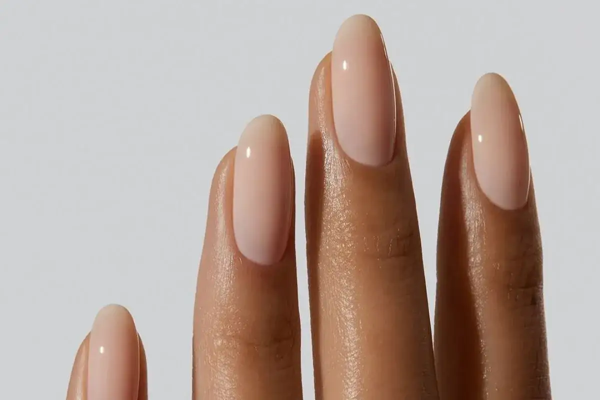Manicura elegante con un color de uñas de moda en tono nude, que realza la belleza natural de las manos.