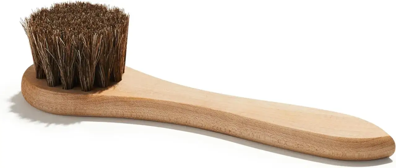 Cepillo de madera con cerdas naturales, ideal para limpiar y hidratar botas de piel, dejándolas como nuevas.