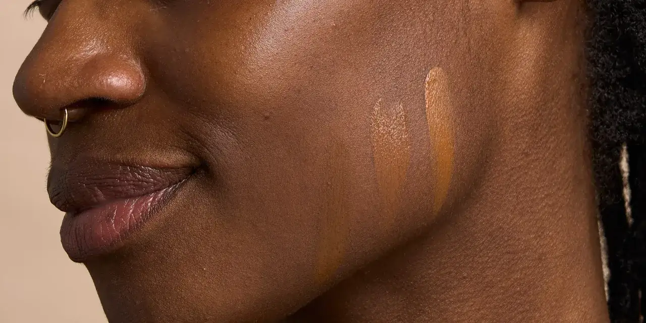Pruebas de tonos de bases de maquillaje en piel oscura, buscando la mejor base de maquillaje.