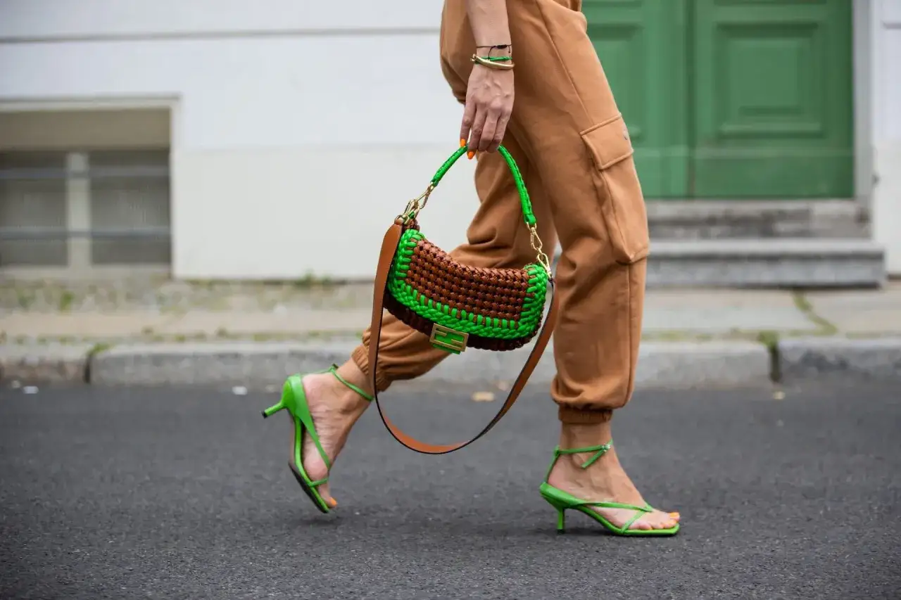 Bolso tejido donde verde y marrón combinan a la perfección, con sandalias a juego y pantalones cargo.