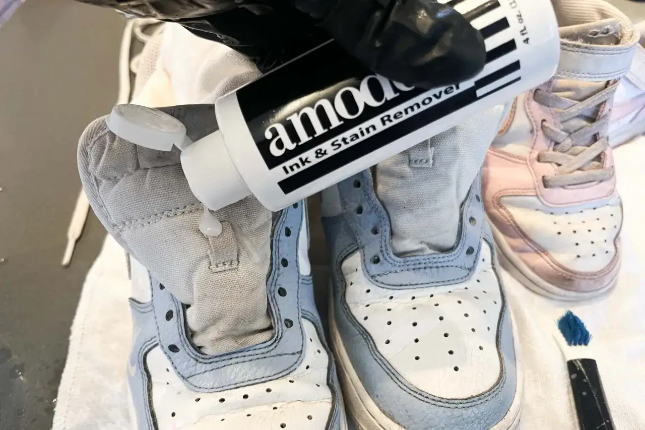Aplicando removedor de manchas para saber como quitar desteñido en zapatillas blancas.