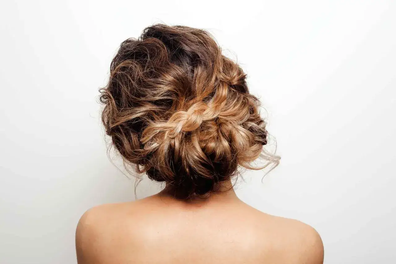 Peinado con recogidos sencillos y elegantes, con un trenzado sutil que resalta el degradado del cabello.