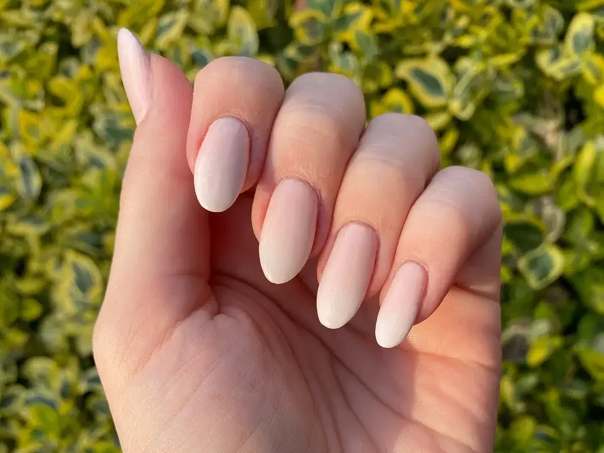Manicura baby boomer natural, con un degradado suave de rosa a blanco en las uñas, luciendo un acabado elegante y delicado.